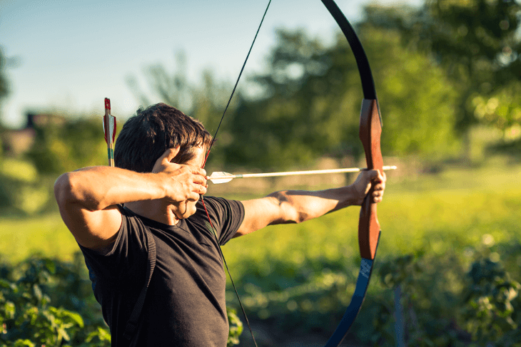 man aiming bow