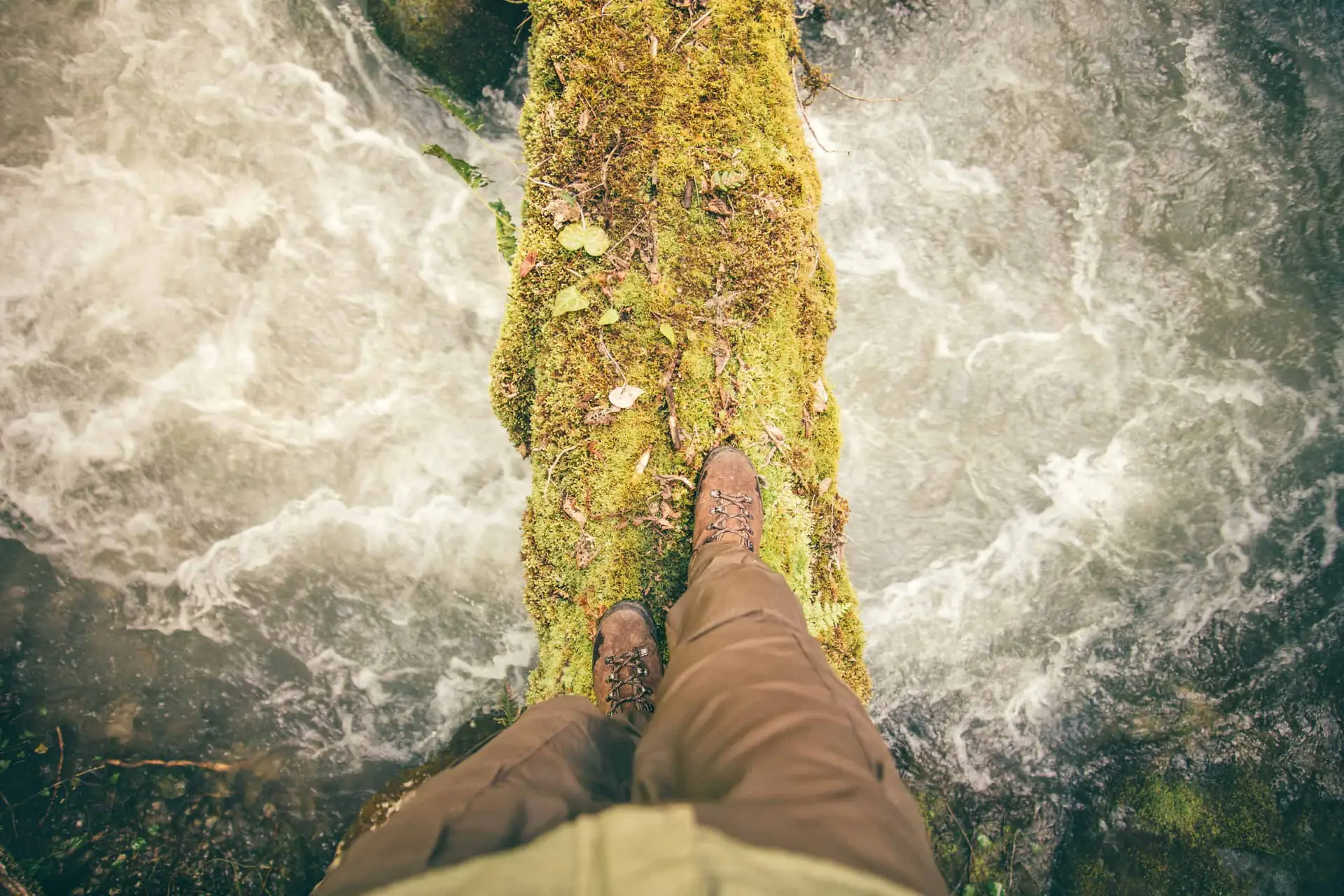 person walking over flowing river