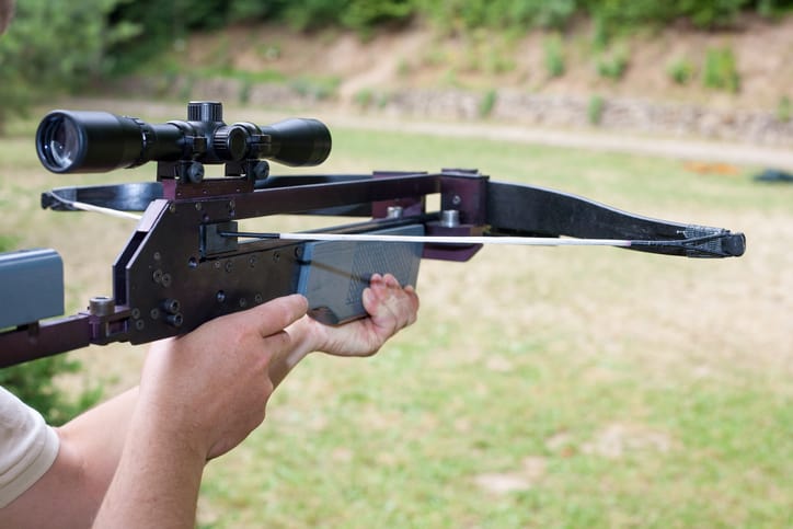 Man holding a scoped crossbow
