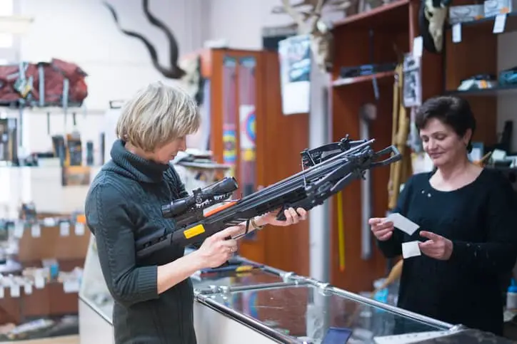 woman examining crossbow